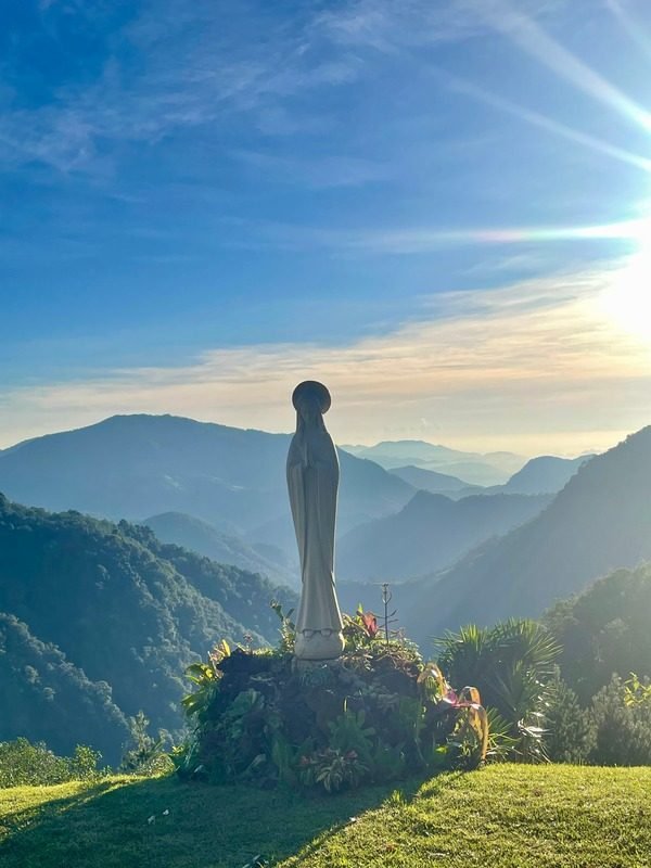 Imagen de la Virgen sobre la montaña al amanecer